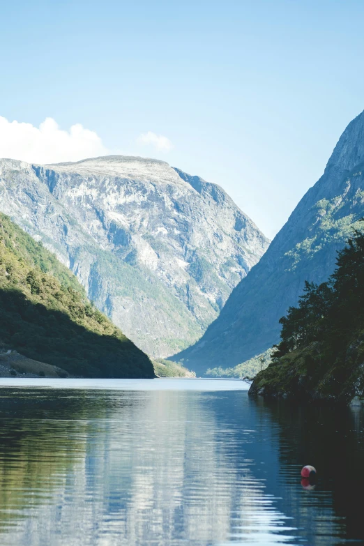 a boat floating on top of a lake near mountains