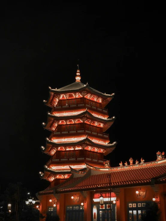 an oriental building lit up at night with lights on it