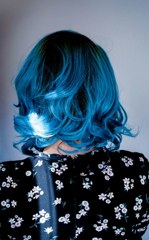 a person with blue hair and a tie wearing black floral dress