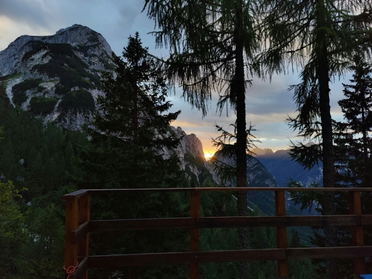 an open wooden fence stands near a mountain view