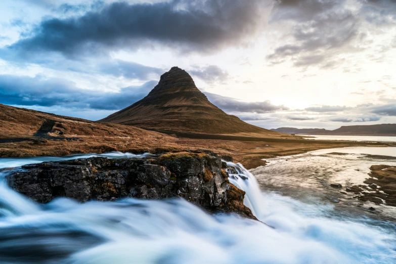 a small waterfall in front of a mountain