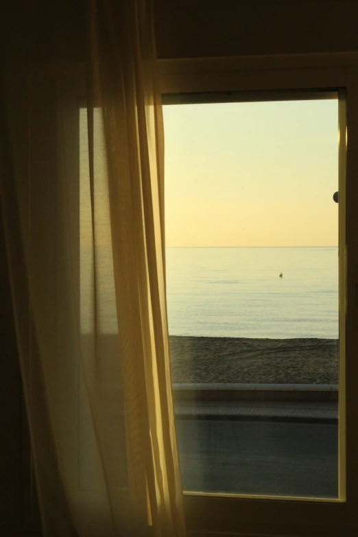 the sea is seen through the window of a home