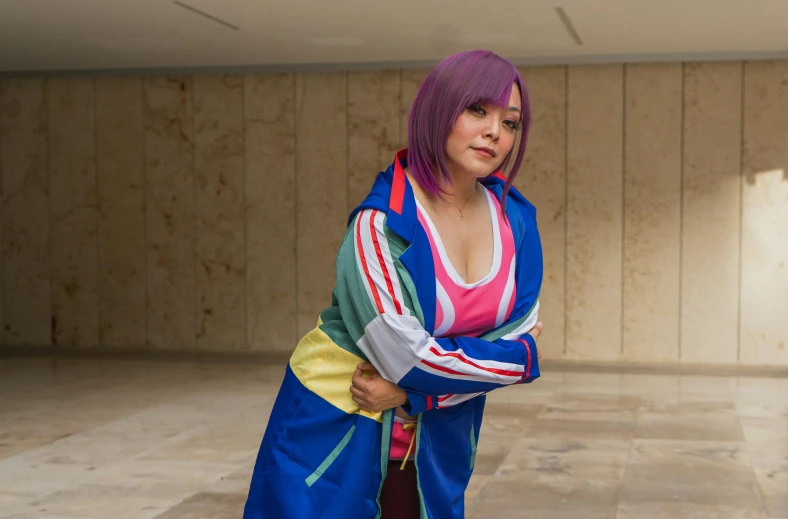 a female with short pink hair is standing wearing a blue robe