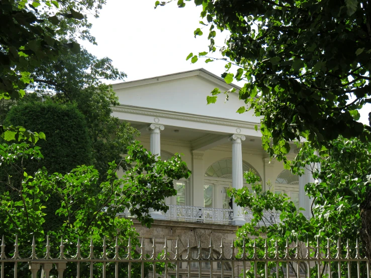 an ornate white house surrounded by trees