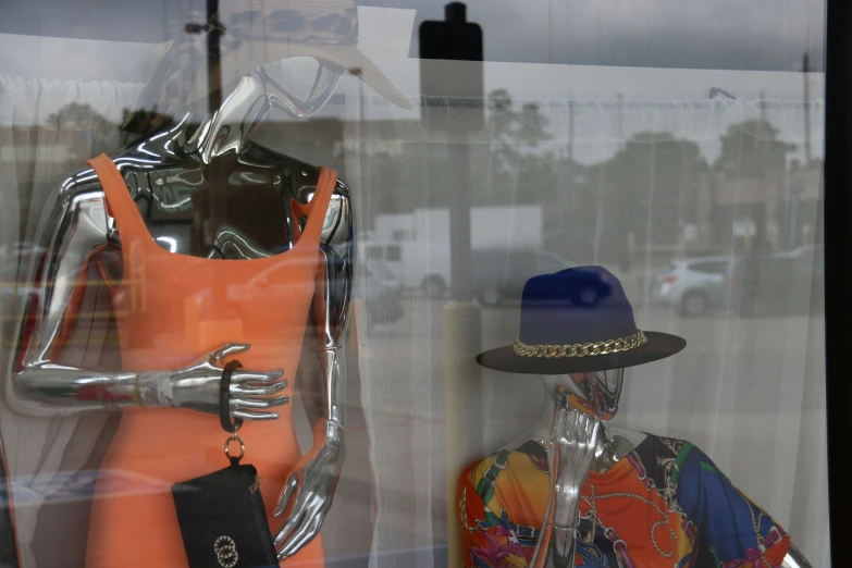 a store window display with a suit and hat on mannequins