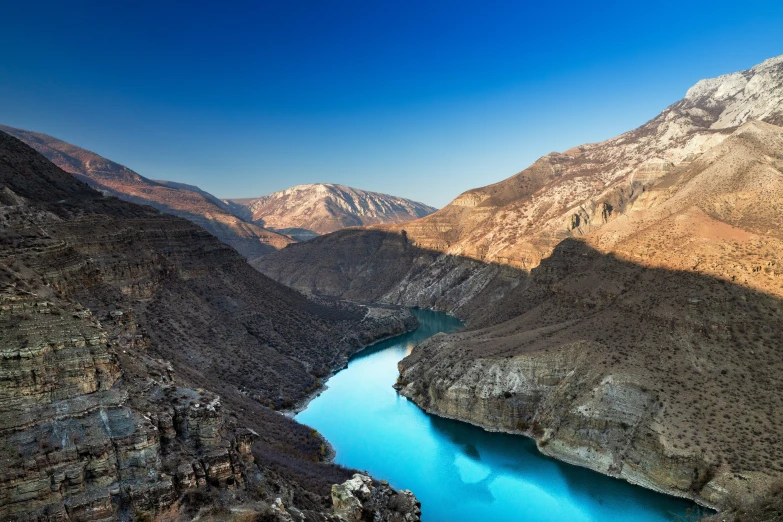 a body of water is surrounded by hills and rocks