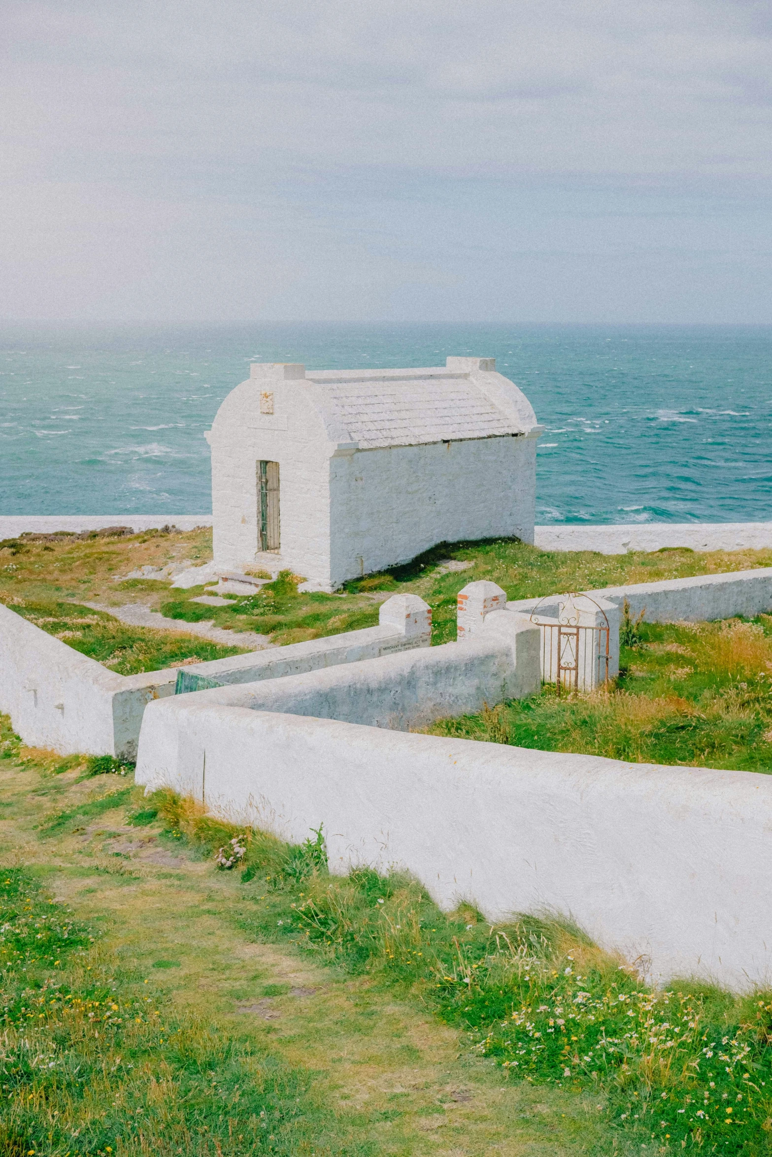 a lone shack sits on the cliff near the ocean