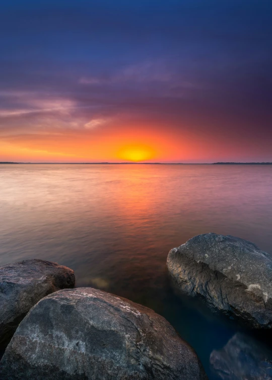 the sun rises over the calm waters at an island