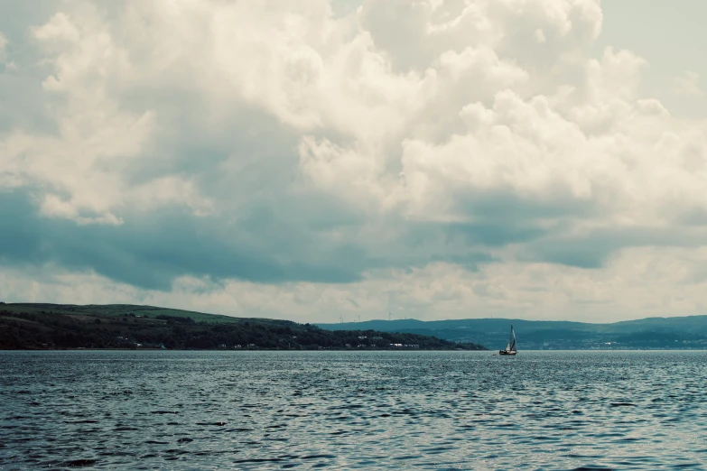 sail boat on water under cloudy skies in a harbor