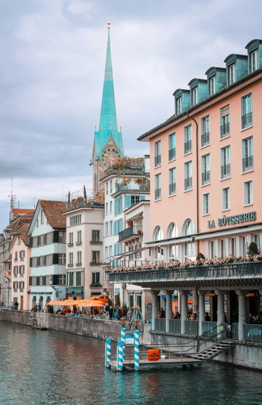 the buildings are next to a river while a blue boat is near