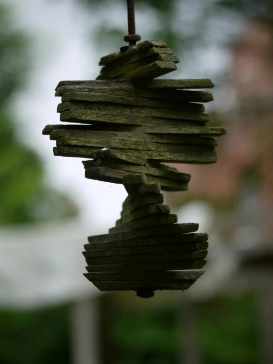 a birdhouse made from logs and a string hanging on it