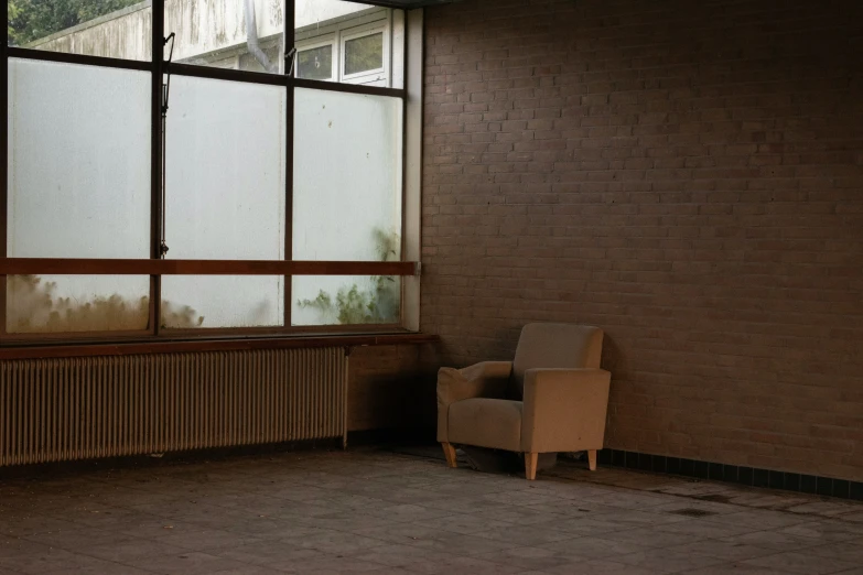 an empty chair sits next to a window in a building