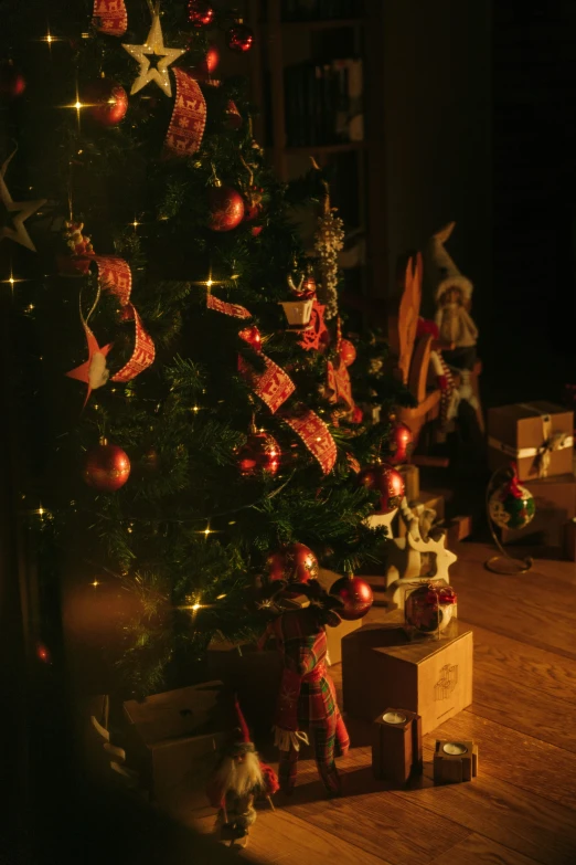 a small christmas tree with presents and a teddy bear near by