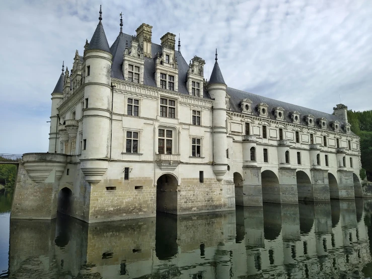 a castle sitting on top of a lush green field next to water