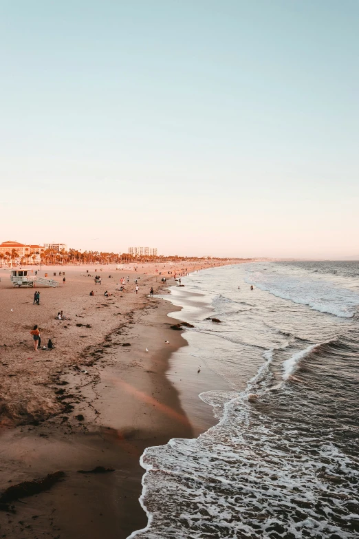 a beach scene with lots of people swimming in the water