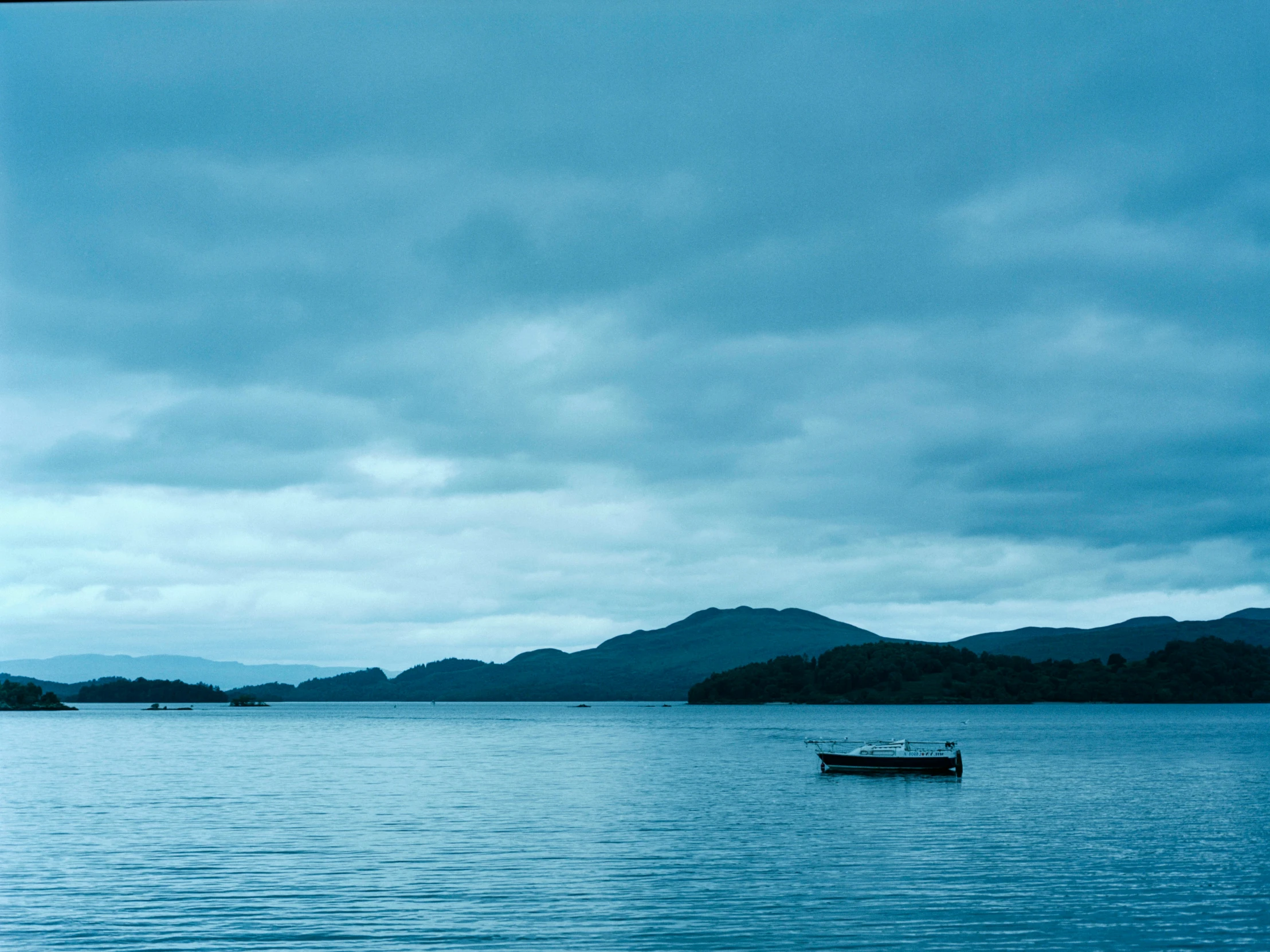 a lone boat floating alone in a calm lake