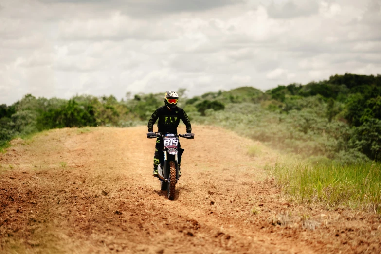 the dirt road is not very muddy and the biker is riding it