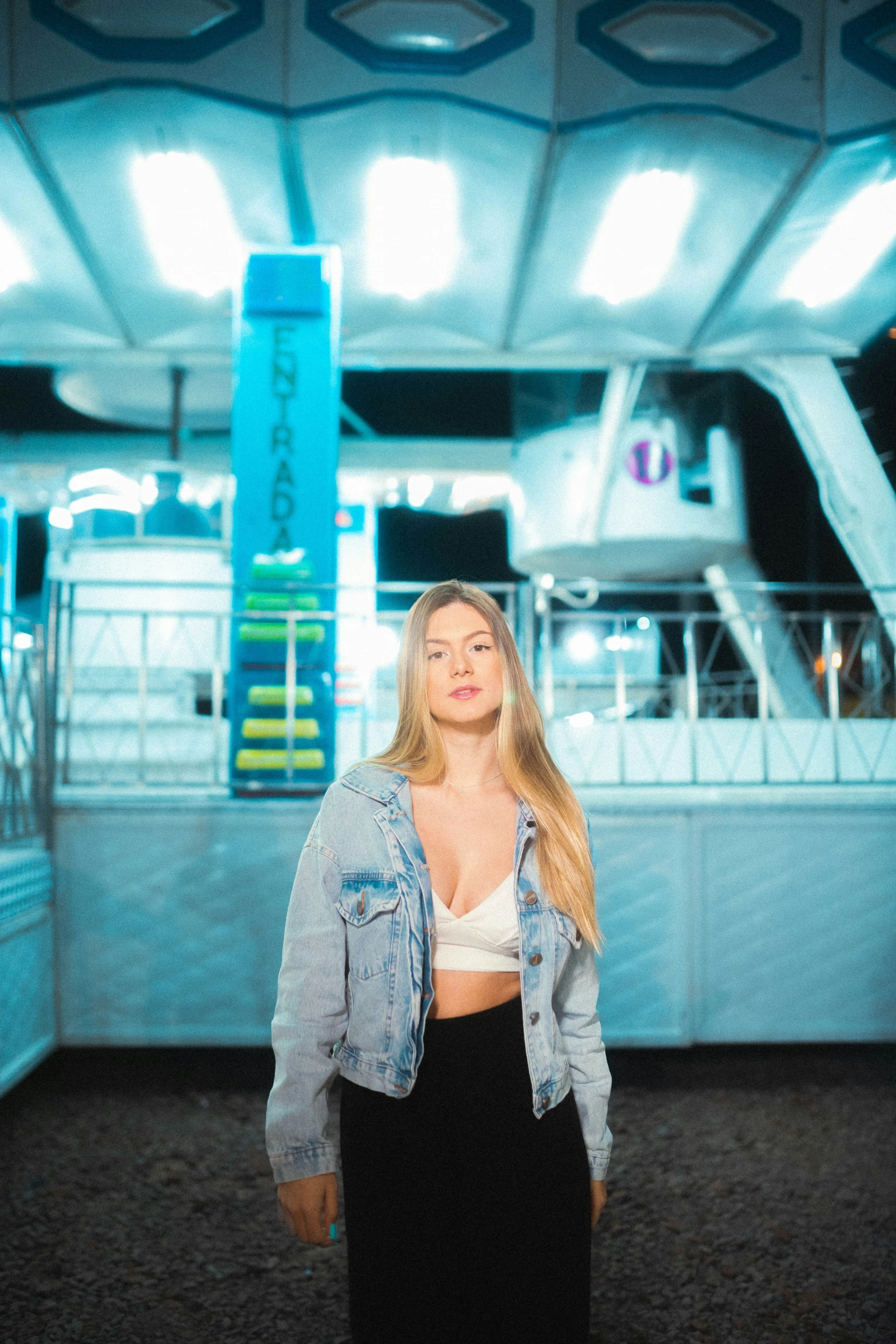 a blonde woman in black skirt and jean jacket on a boat