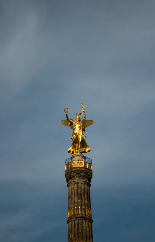 the angel atop the building is lit up in the sky