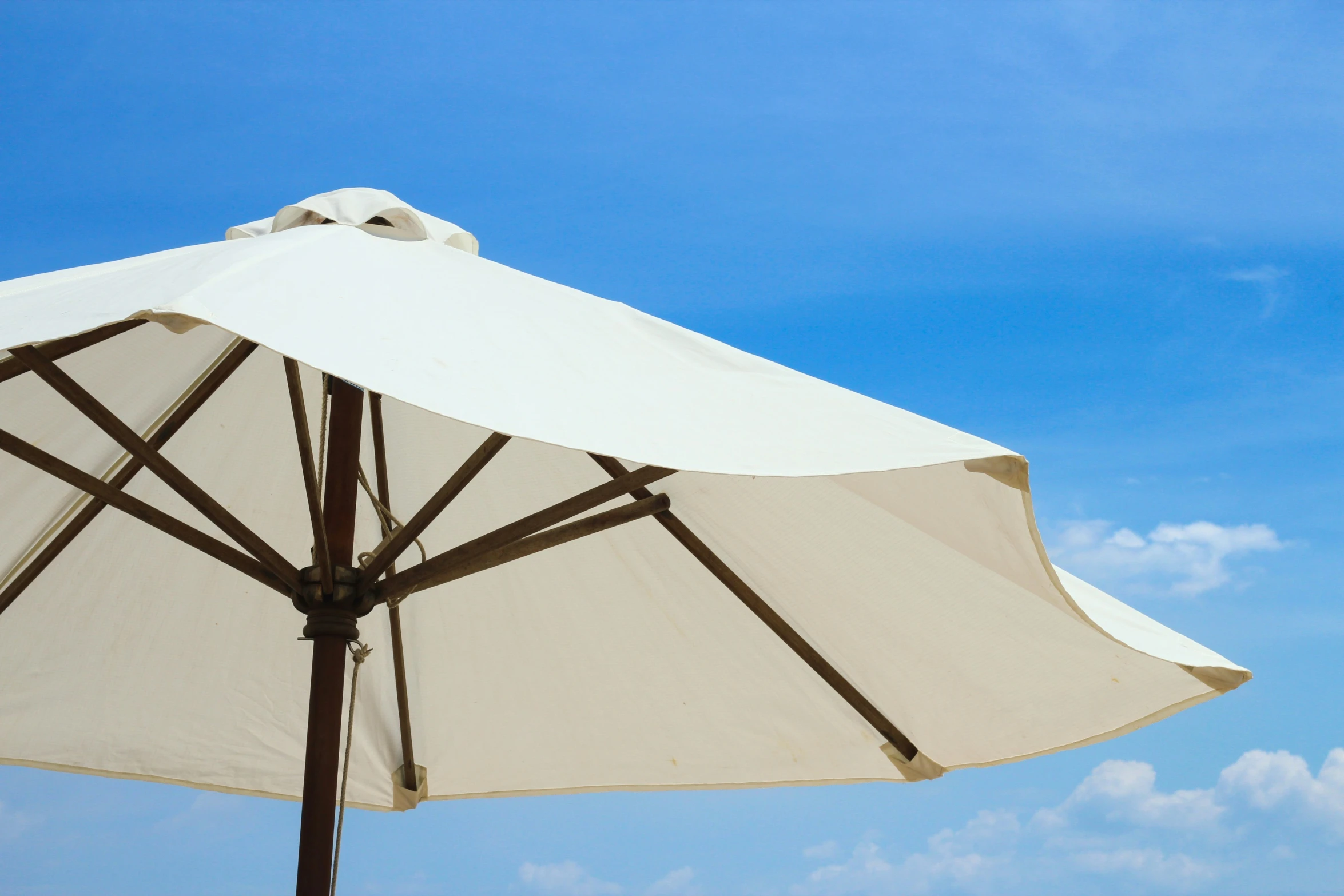 an umbrella and some white clouds and blue sky