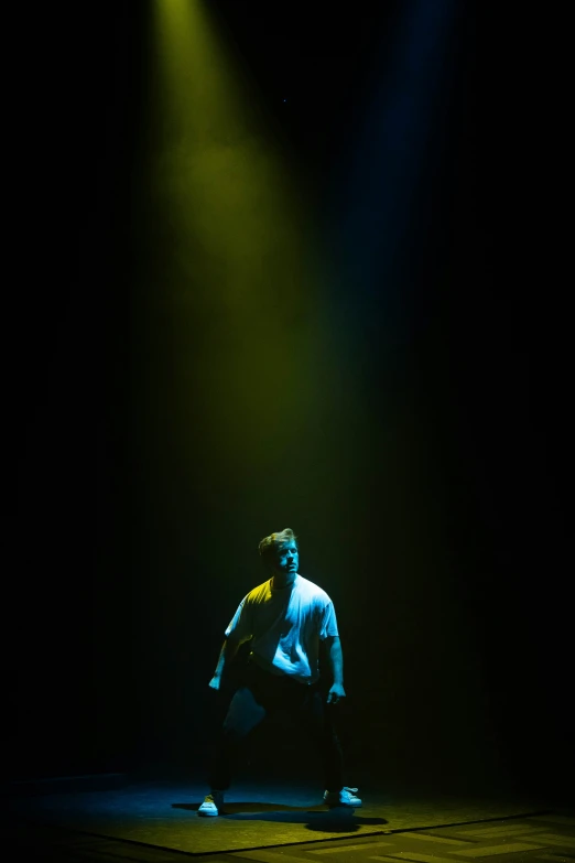 a male performer is performing in a dark lit room