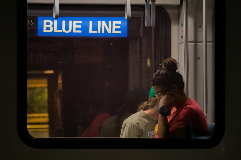 two people in a subway one on a cell phone