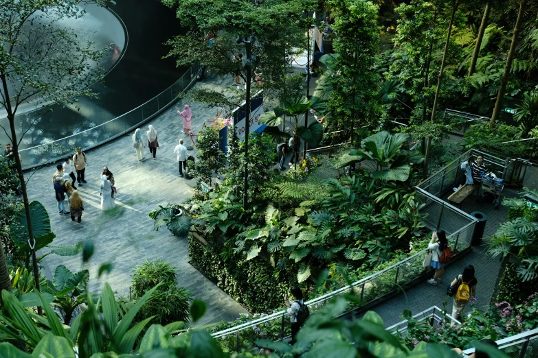 several people walking through a garden on an elevated platform