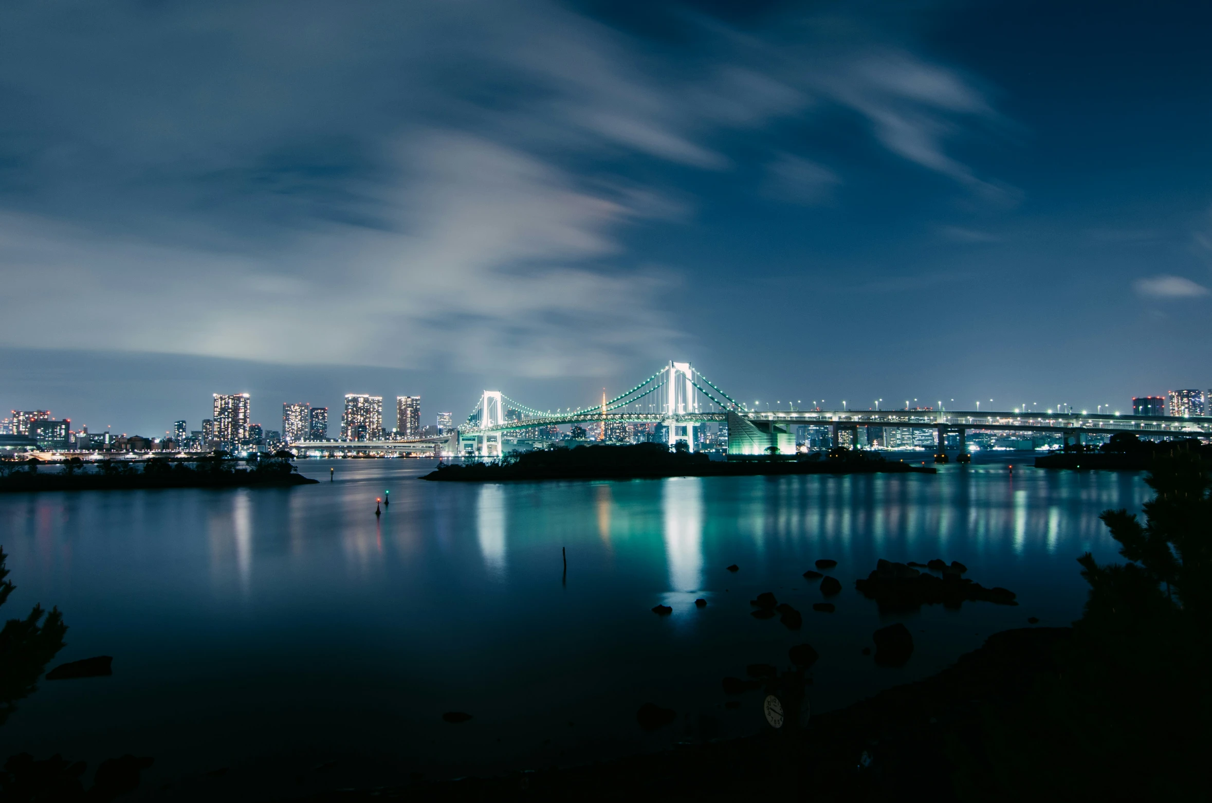 the skyline of the city is shown lit up in the dark blue lights