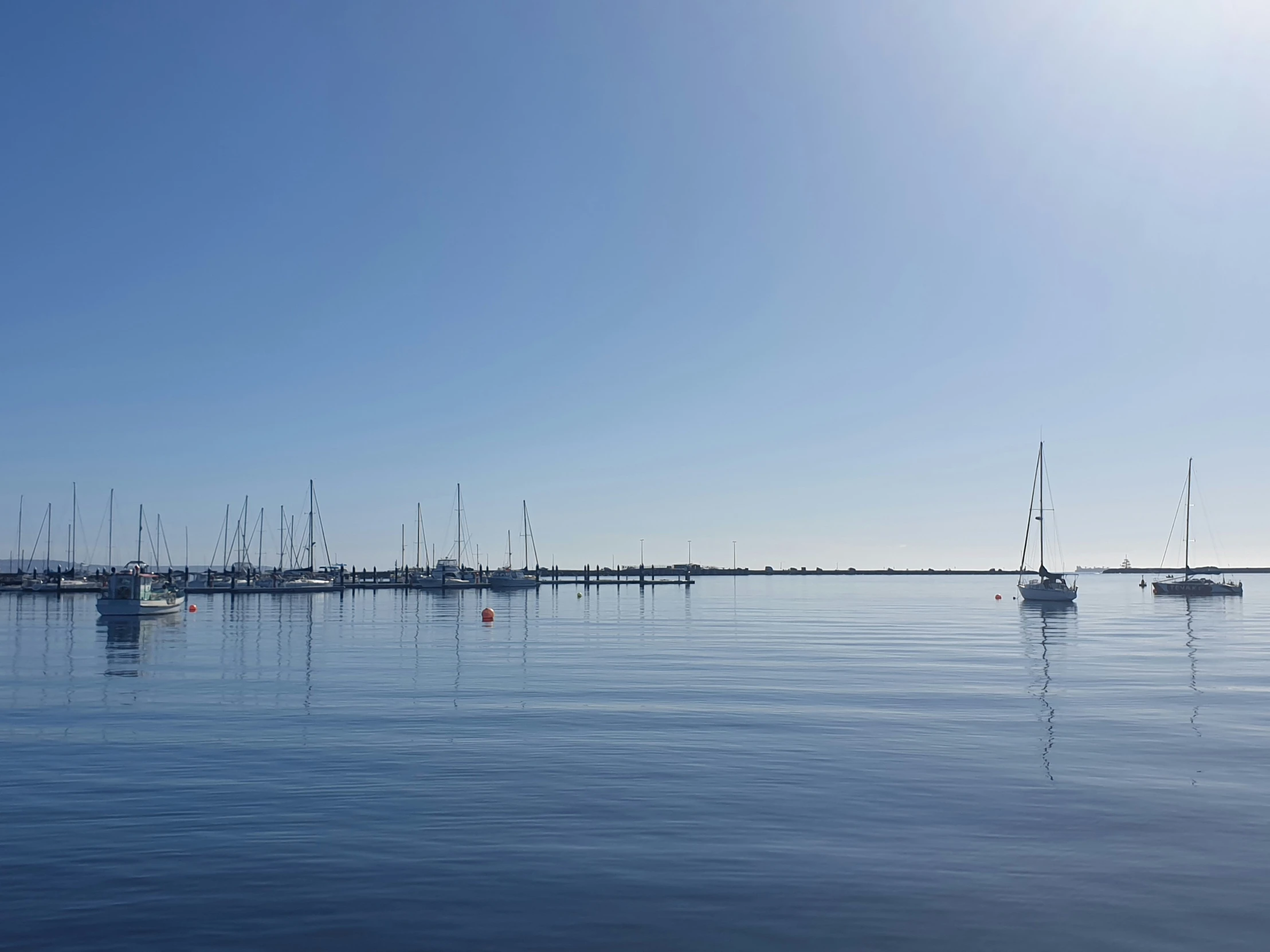 boats are sailing on the water in the sun