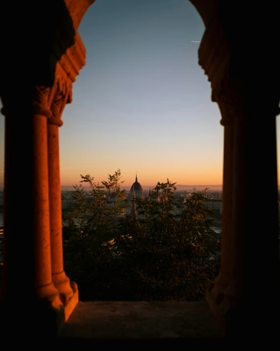 an arch in a building with a view to the city below