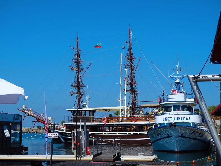 an old fashioned boat that is moored by a pier