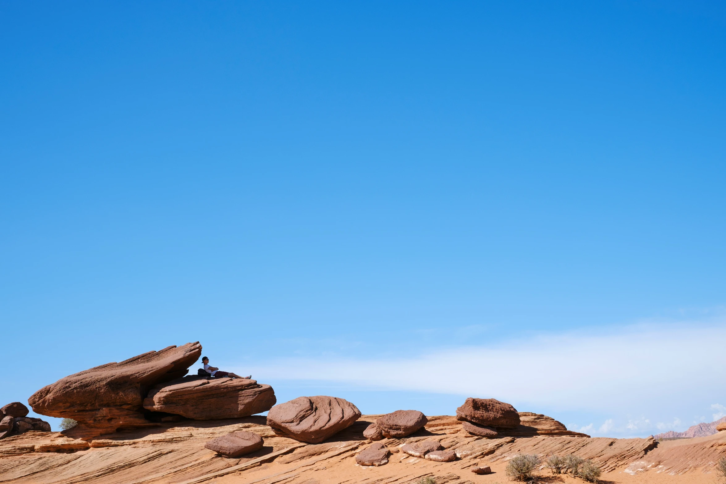 several large rocks on top of a mountain under a blue sky