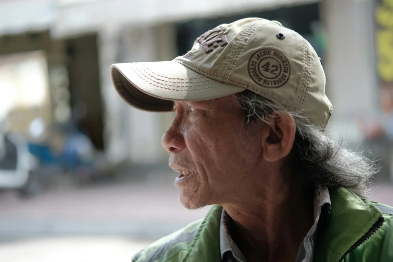 a man with long hair wearing a tan hat