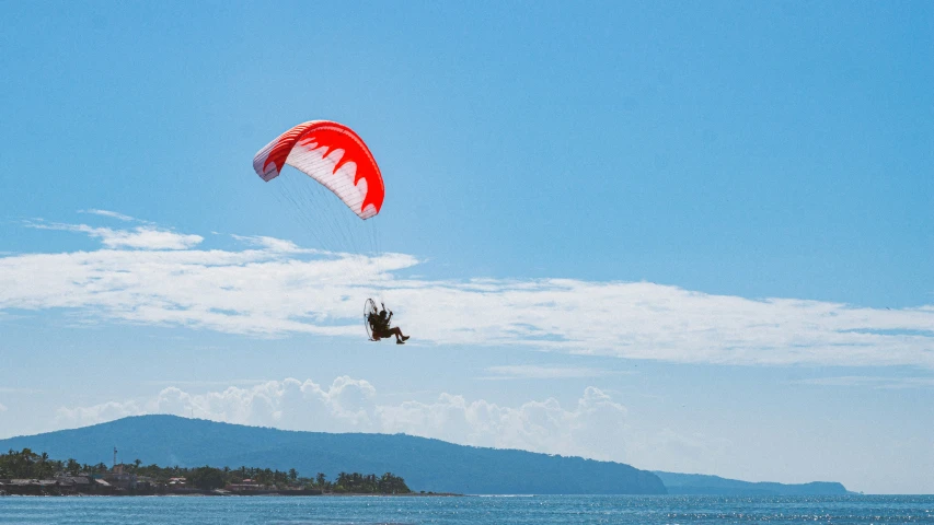 there is a man that is parasailing over the water