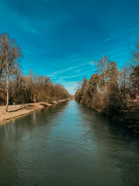 a river runs under a bright blue sky with no clouds