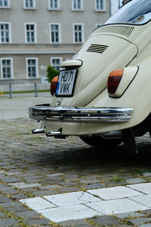 a white beetle parked next to a building