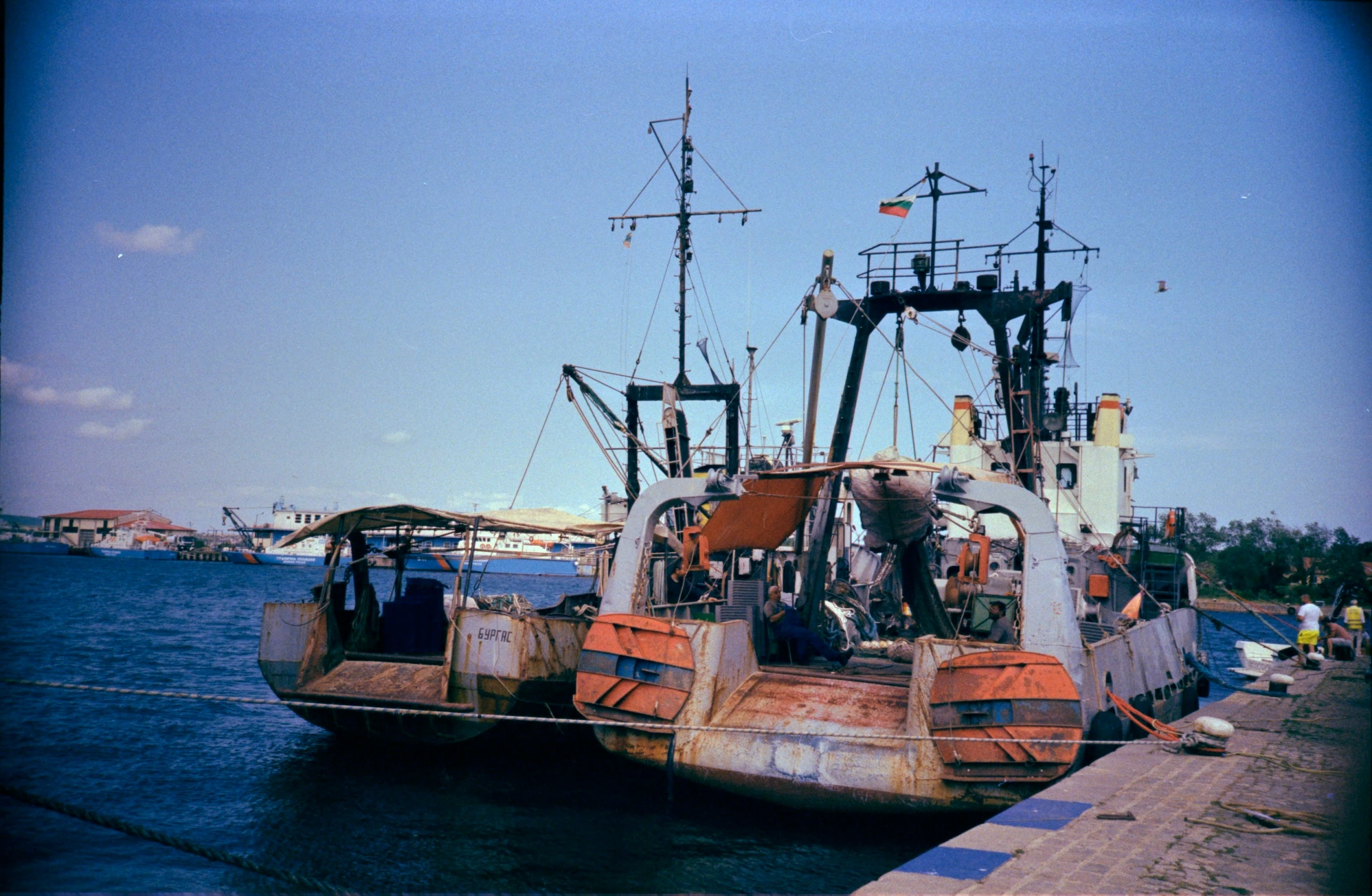 a rusted out ship docked at a pier