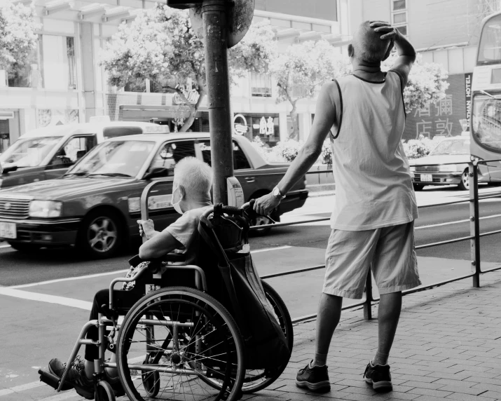 the young man is using his wheelchair to help his friend get out of a wheelchair