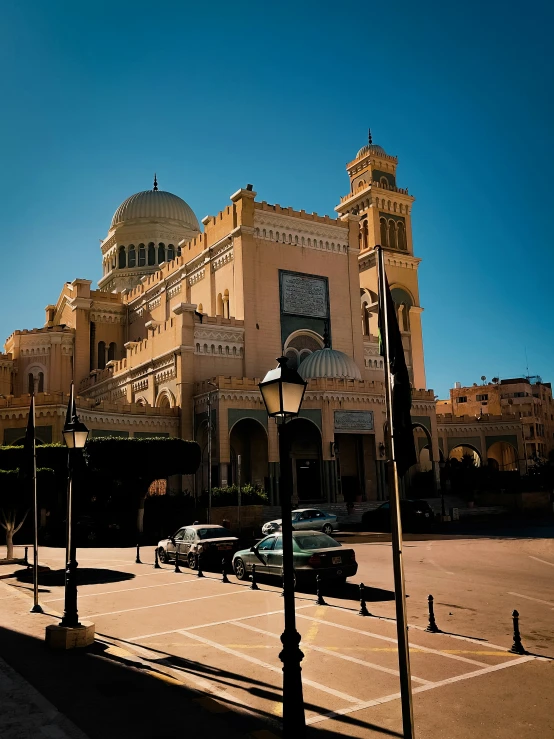 cars parked in front of an elegant building on a sunny day