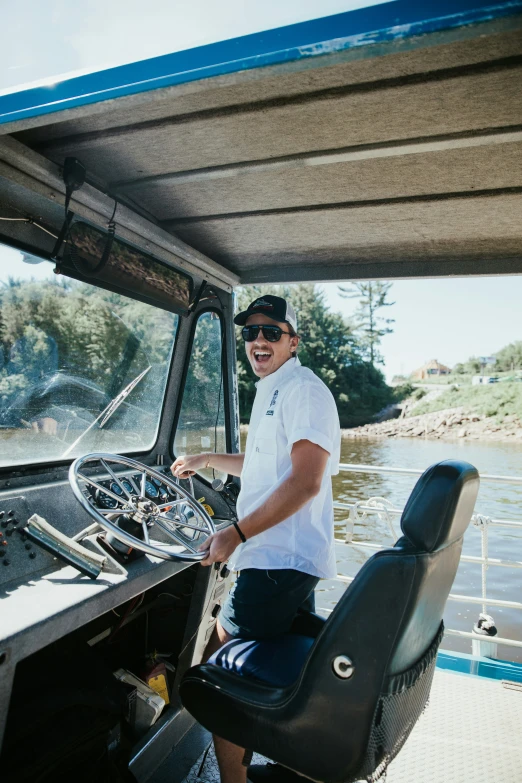 a man sitting at the controls on a small boat