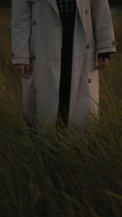 the woman is walking through the grass in the woods