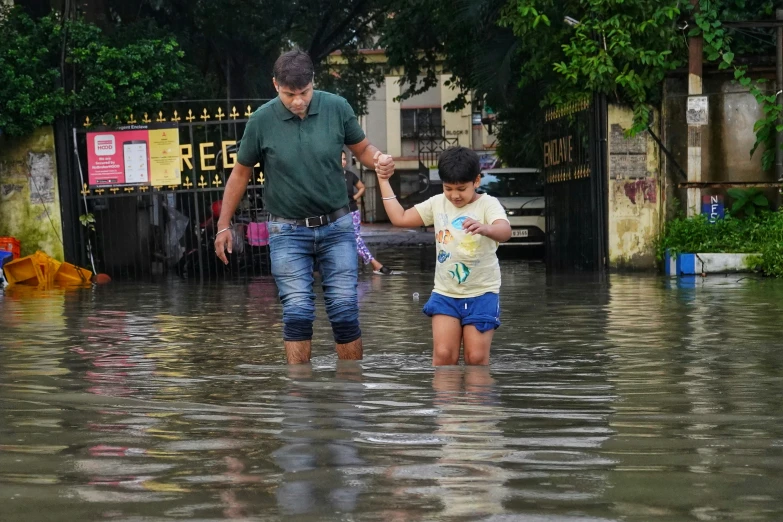 two people are walking through the flood water