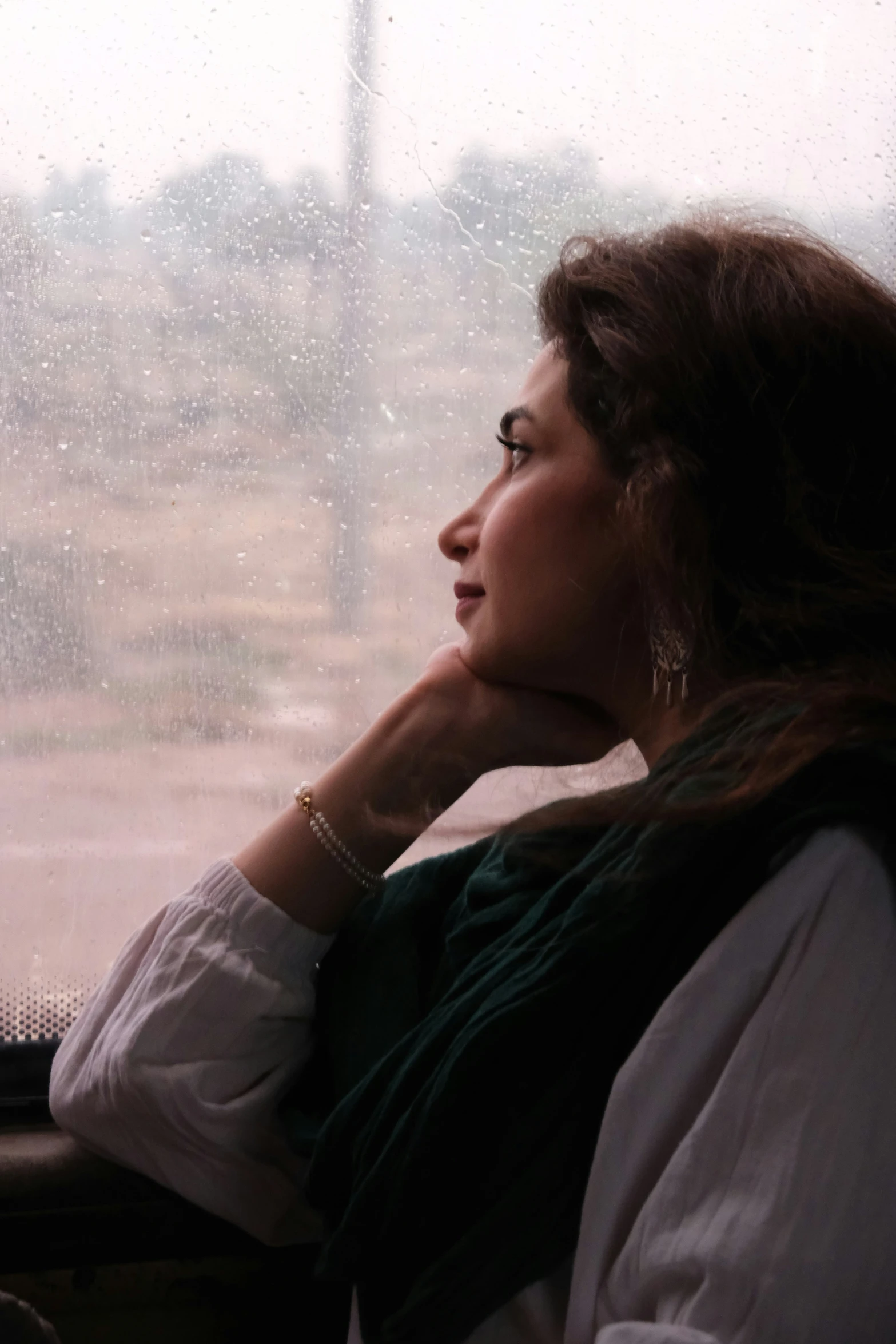 a woman looking out a window while she looks outside