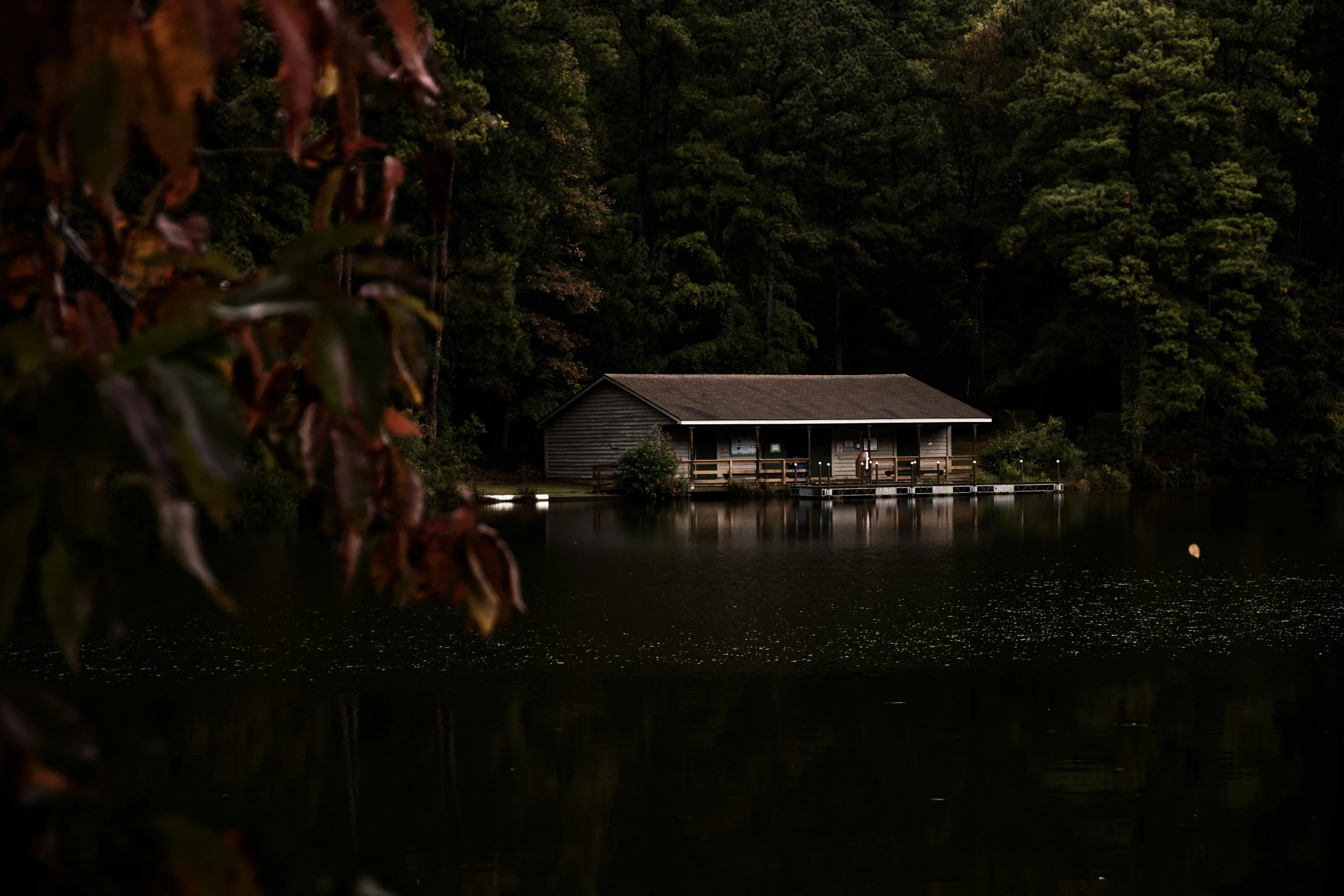 a cabin sitting on top of a body of water surrounded by trees