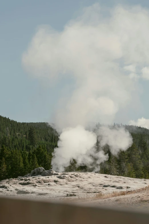 an old fashioned steam furnace emitting smoke out of the ground