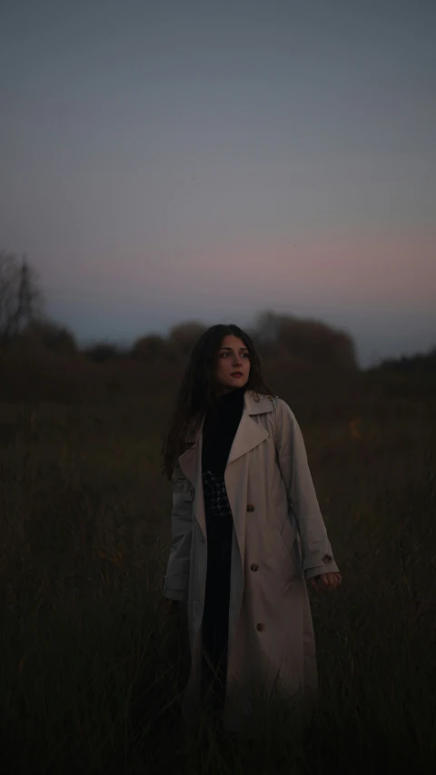 woman walking through field in dark and gloomy weather