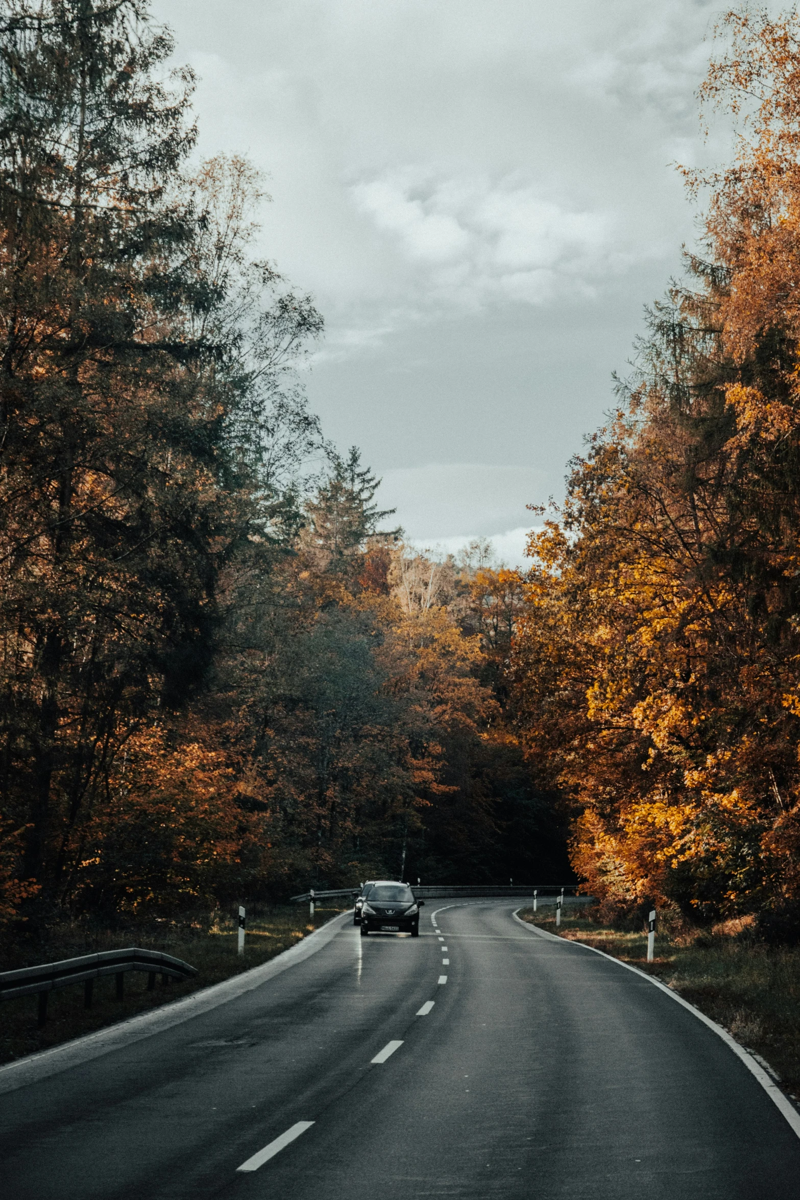 a vehicle parked on the side of a road in the fall