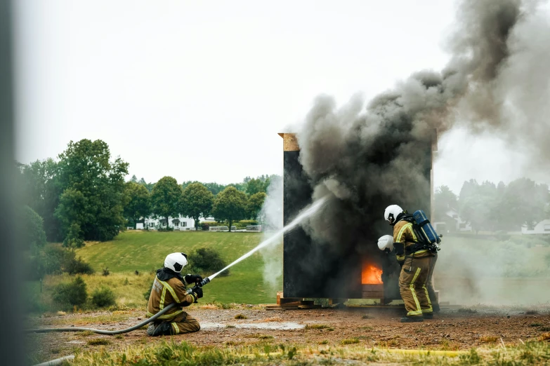 firefighters using a water hose to extinguish fire at a building