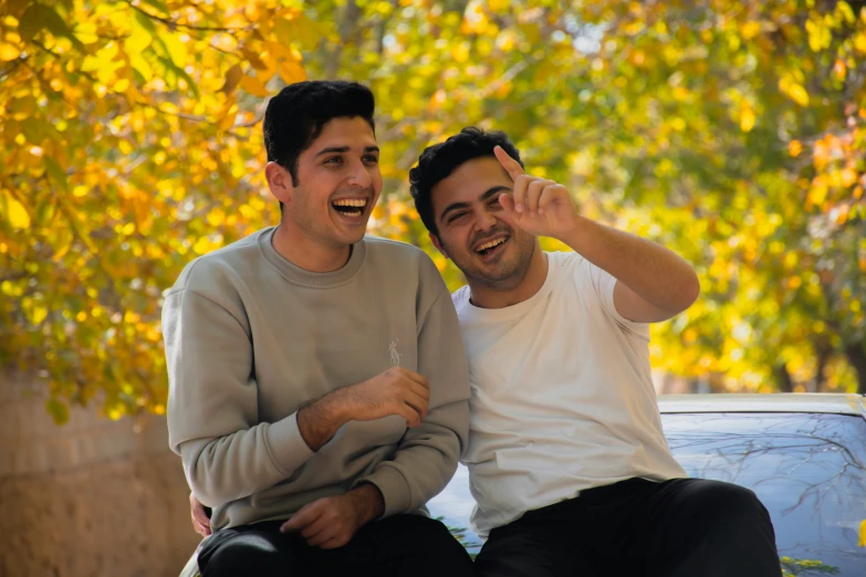 two guys are posing for a picture outside