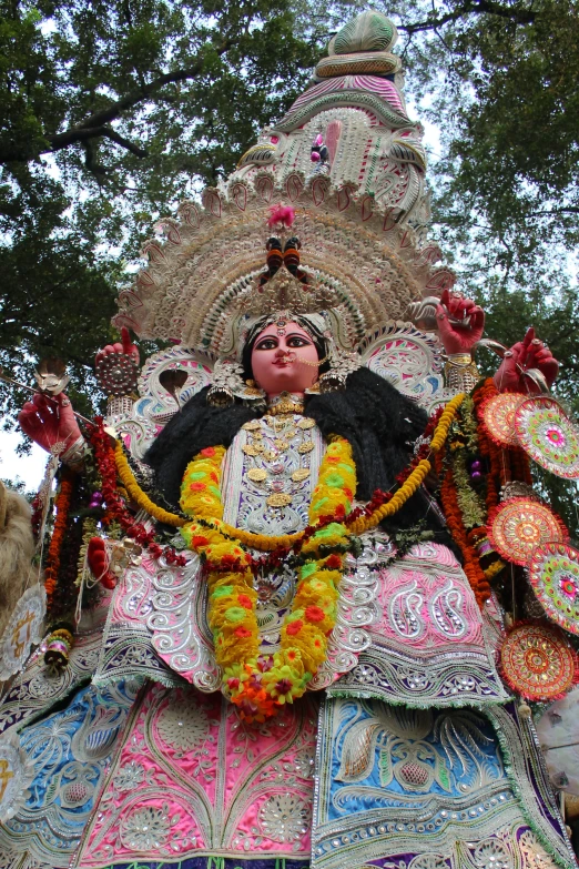 a man with elaborate clothing sitting on a large decorative sculpture